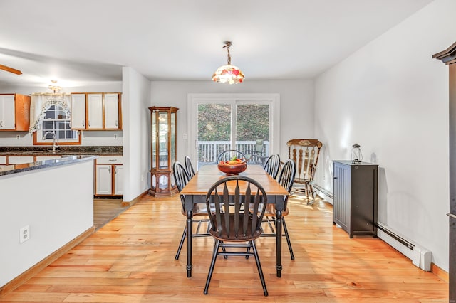 dining space featuring sink, a baseboard heating unit, light hardwood / wood-style flooring, and ceiling fan