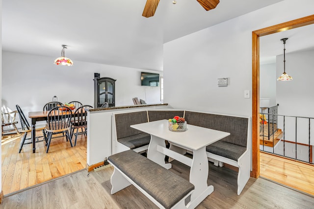 dining space with ceiling fan and light wood-type flooring