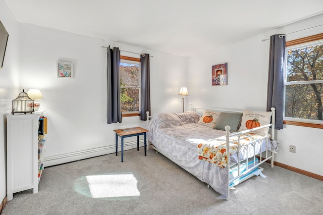 bedroom with carpet flooring, multiple windows, and a baseboard heating unit