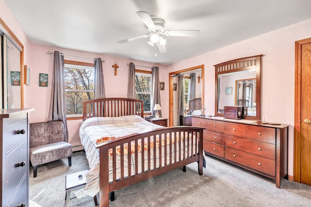 carpeted bedroom featuring baseboard heating and ceiling fan