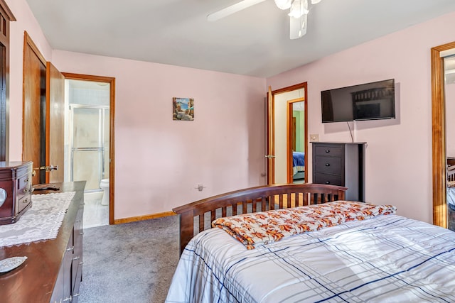 bedroom featuring light carpet, ensuite bathroom, and ceiling fan