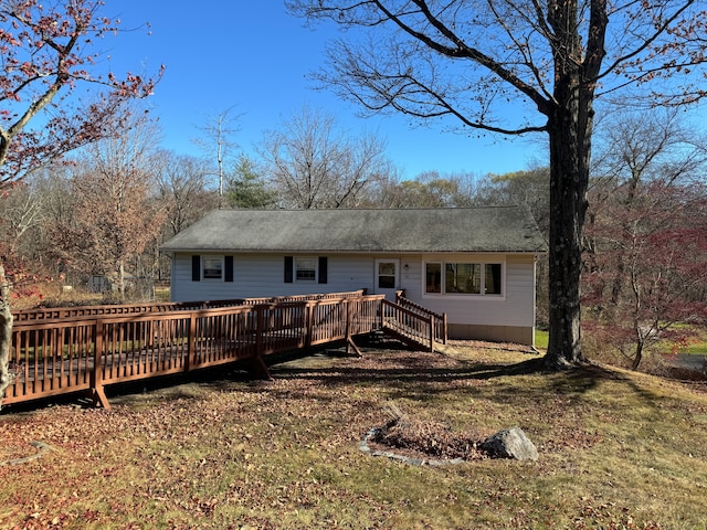 rear view of house with a lawn and a deck