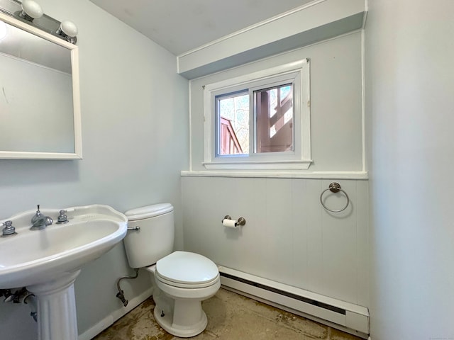 bathroom featuring sink, toilet, and a baseboard heating unit