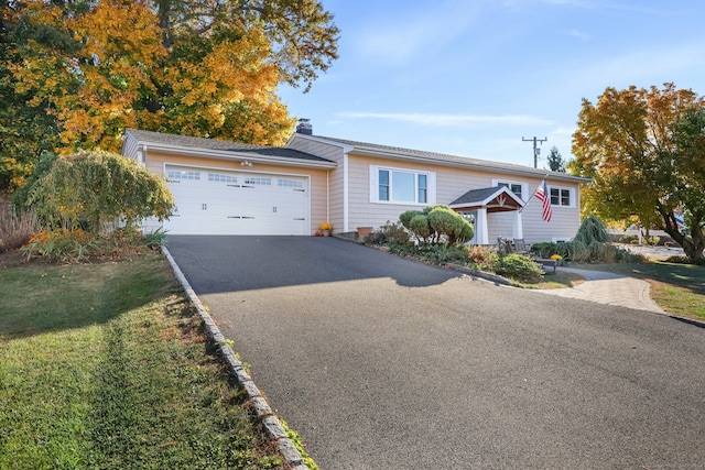 ranch-style home featuring a front yard and a garage