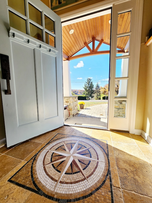 doorway to outside with wooden ceiling and vaulted ceiling