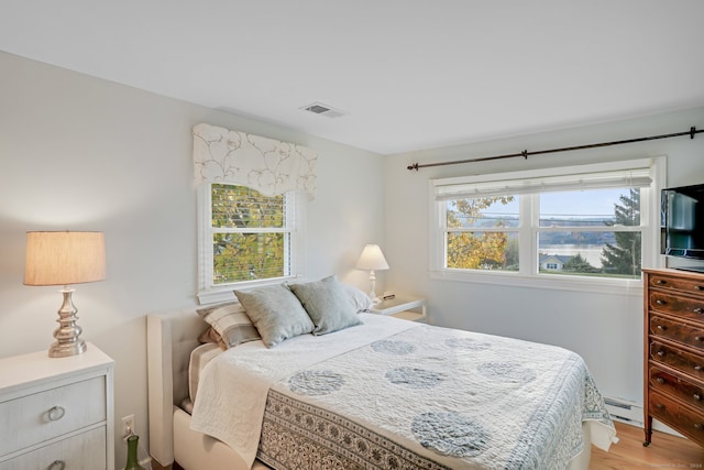 bedroom featuring baseboard heating and light wood-type flooring