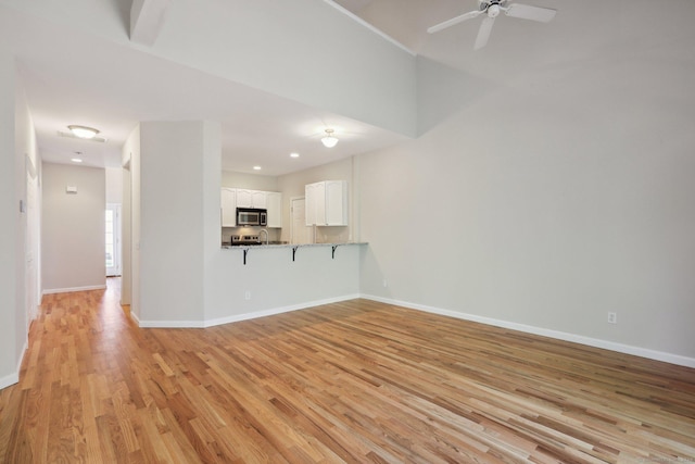 unfurnished living room with ceiling fan and light hardwood / wood-style floors