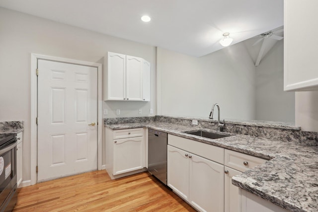 kitchen with appliances with stainless steel finishes, sink, white cabinets, light stone counters, and light hardwood / wood-style floors