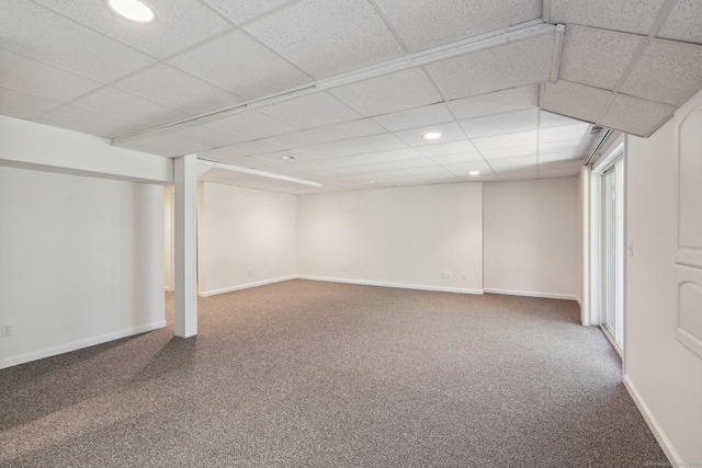 basement featuring a paneled ceiling and carpet