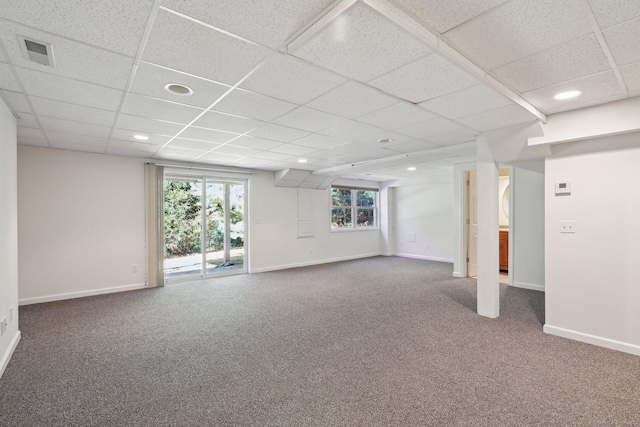 basement with a healthy amount of sunlight, carpet floors, and a drop ceiling