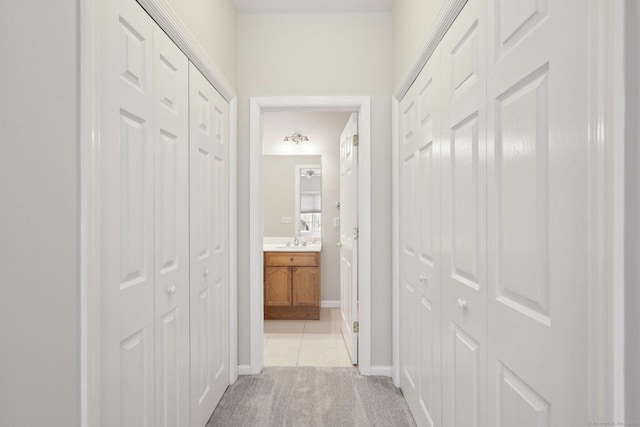 hall featuring light colored carpet and sink