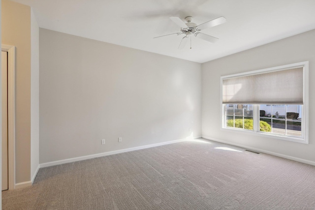 spare room with ceiling fan and carpet