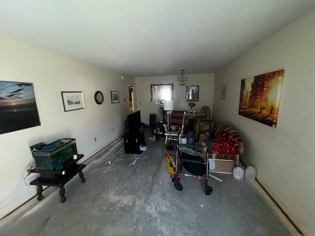 living room featuring a chandelier and concrete flooring