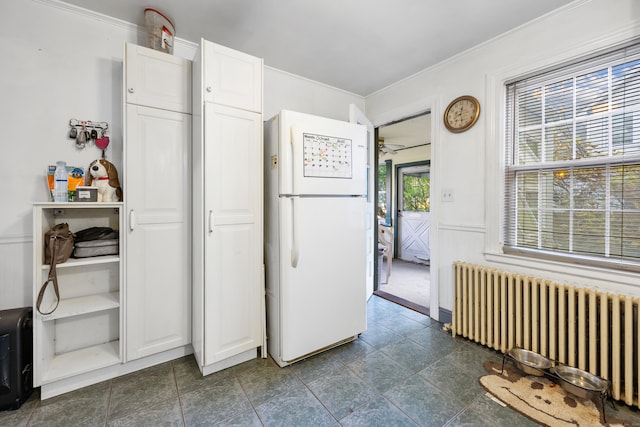 kitchen with ornamental molding, white refrigerator, white cabinets, radiator heating unit, and ceiling fan