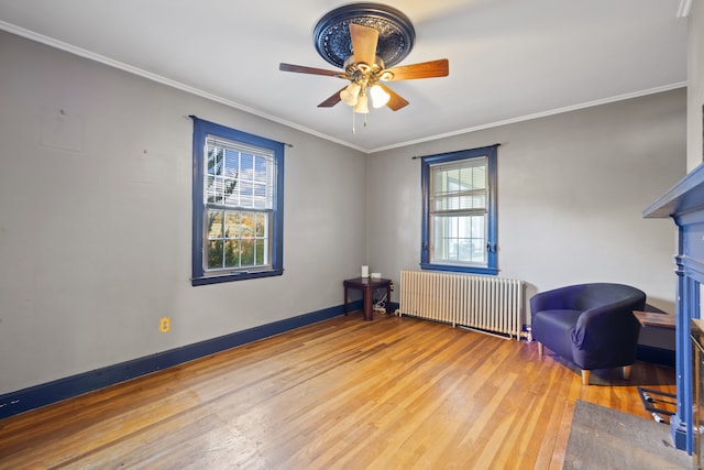 sitting room with ornamental molding, radiator heating unit, hardwood / wood-style floors, and ceiling fan