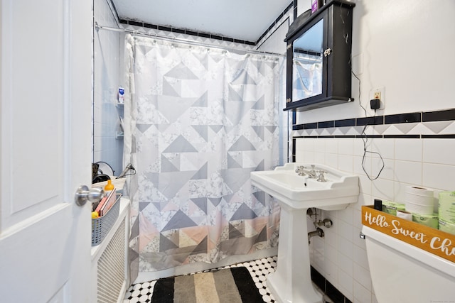 bathroom with toilet, tile patterned floors, tile walls, and curtained shower