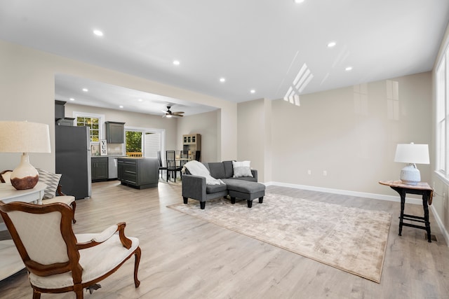 living room with light hardwood / wood-style floors and ceiling fan