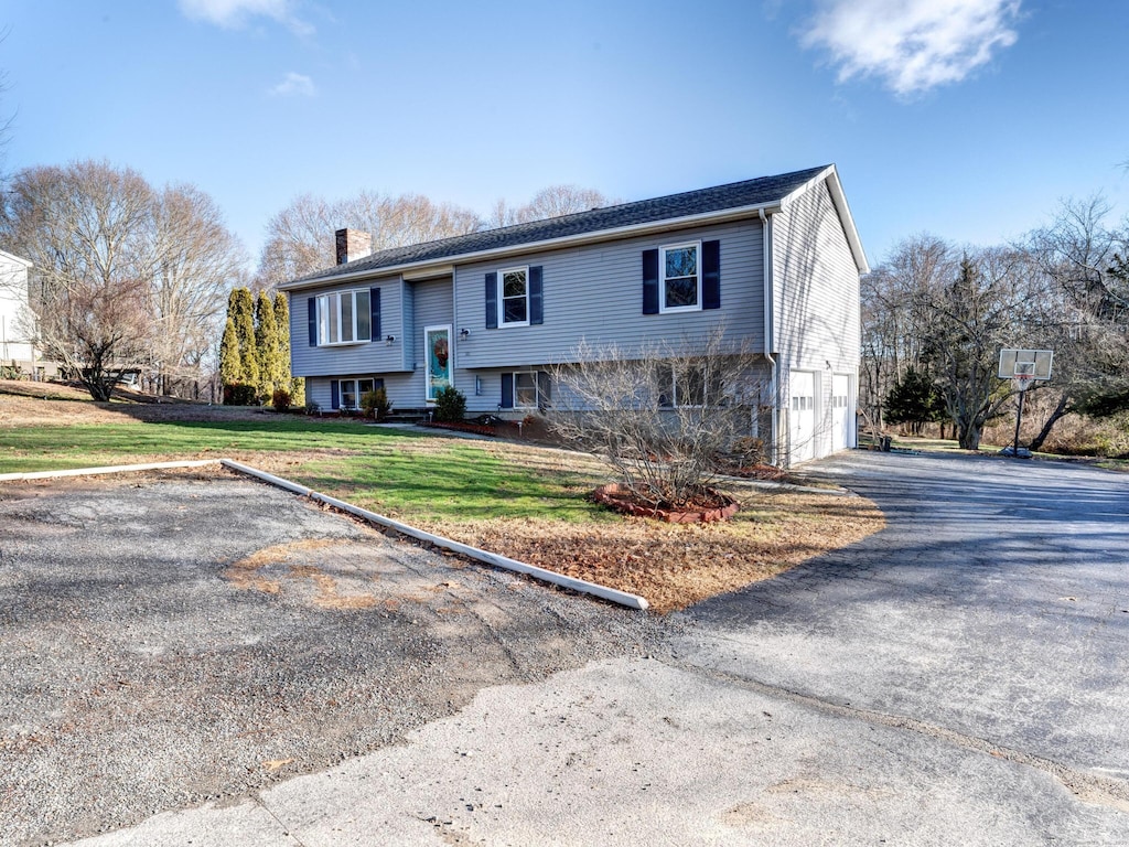 bi-level home with a front yard and a garage