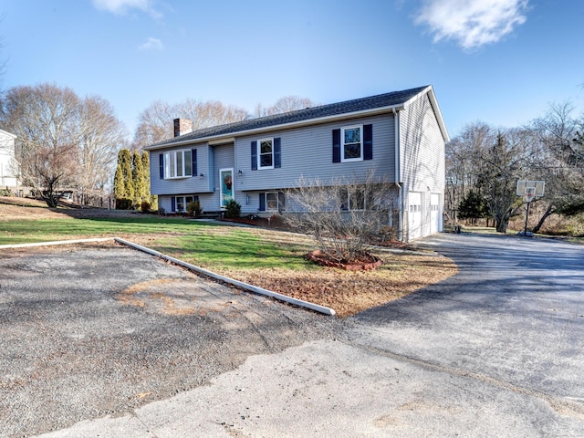 bi-level home with a front yard and a garage