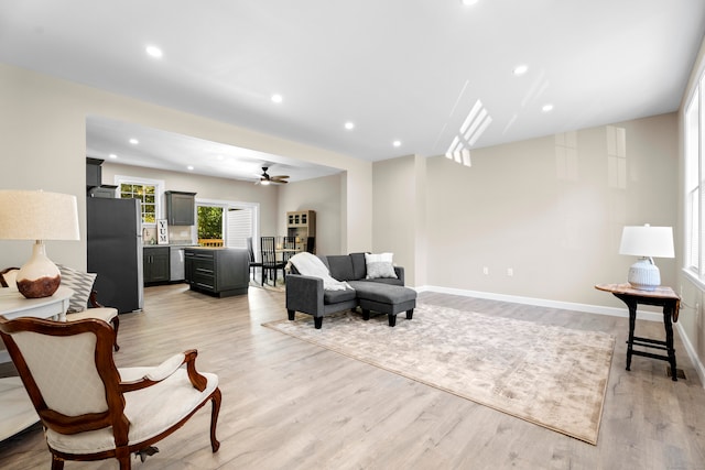 living room with ceiling fan and light hardwood / wood-style flooring