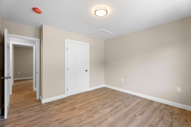 unfurnished bedroom featuring a closet and light wood-type flooring