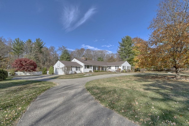 ranch-style house featuring a garage and a front lawn