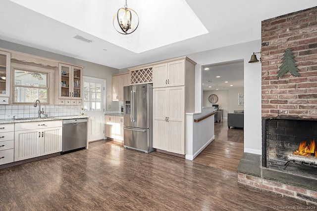 kitchen featuring sink, hanging light fixtures, dark hardwood / wood-style flooring, decorative backsplash, and appliances with stainless steel finishes