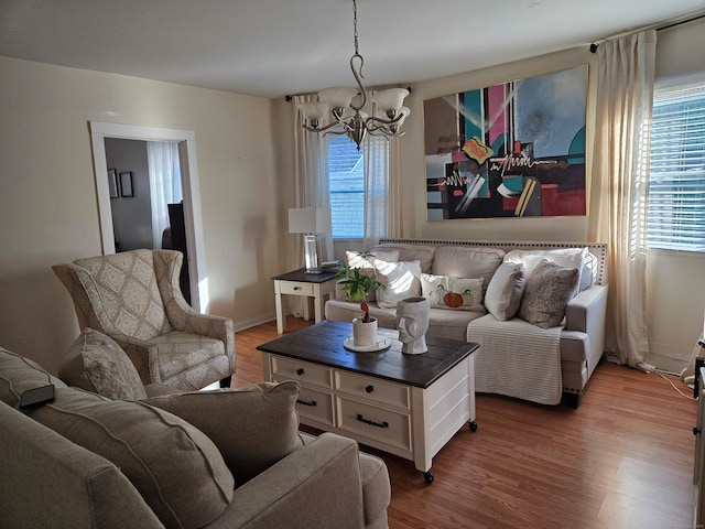 living room featuring a notable chandelier, wood-type flooring, and plenty of natural light