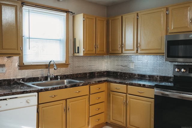 kitchen with backsplash, stainless steel appliances, light brown cabinetry, and sink