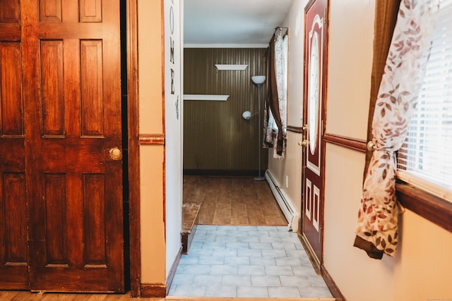 hallway featuring light hardwood / wood-style floors, ornamental molding, and a baseboard radiator