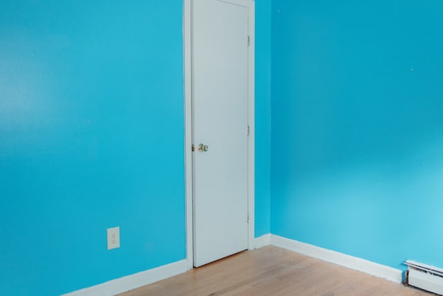 empty room with a baseboard heating unit and light wood-type flooring