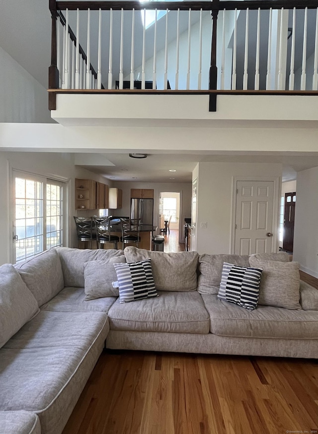 living room featuring a high ceiling, a wealth of natural light, and wood-type flooring