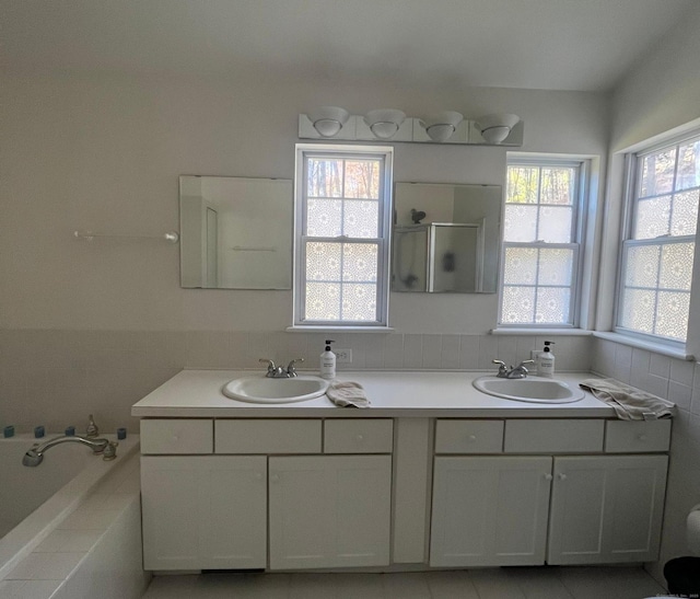 bathroom with plus walk in shower, vanity, and plenty of natural light