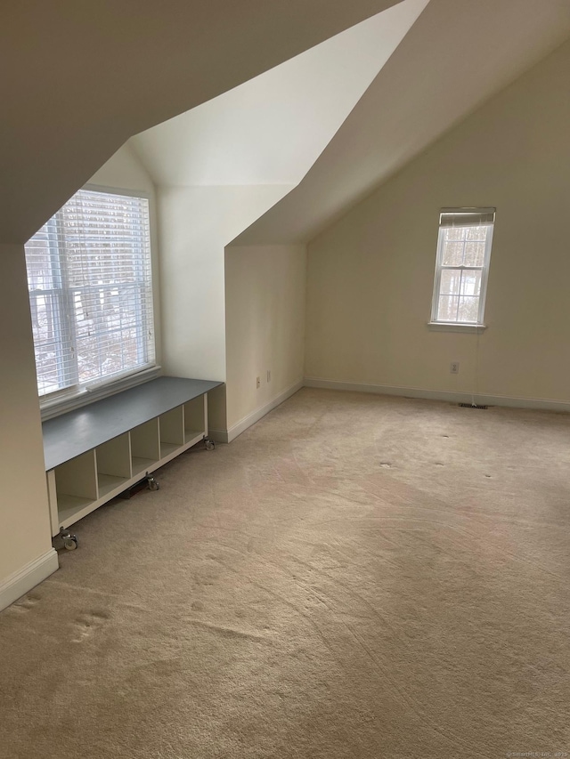 bonus room with light colored carpet and lofted ceiling