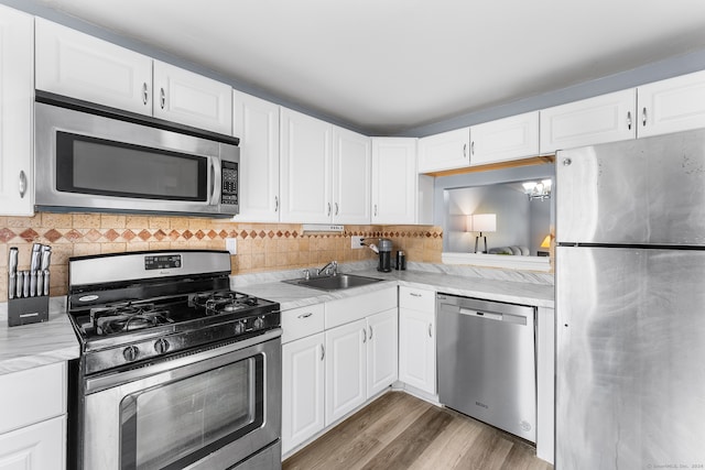 kitchen featuring appliances with stainless steel finishes, white cabinetry, tasteful backsplash, and dark hardwood / wood-style floors