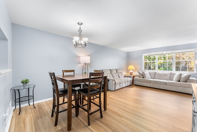 dining room with light hardwood / wood-style floors and a chandelier