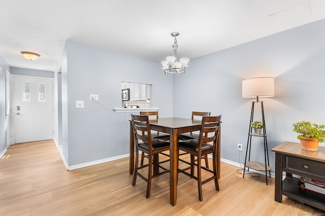 dining space featuring an inviting chandelier and light wood-type flooring