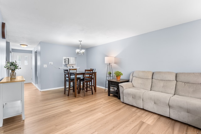 living room with a chandelier and light wood-type flooring