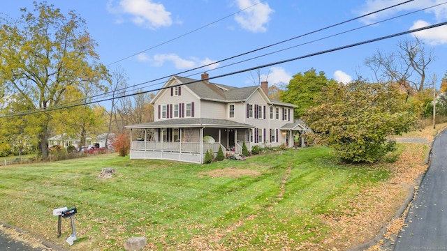 farmhouse inspired home with a front lawn and a sunroom