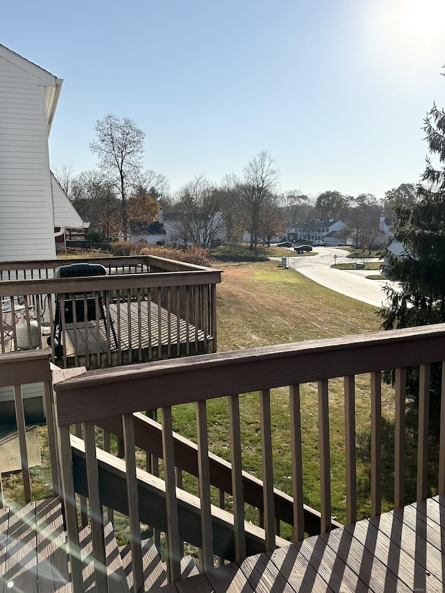 wooden terrace featuring a lawn