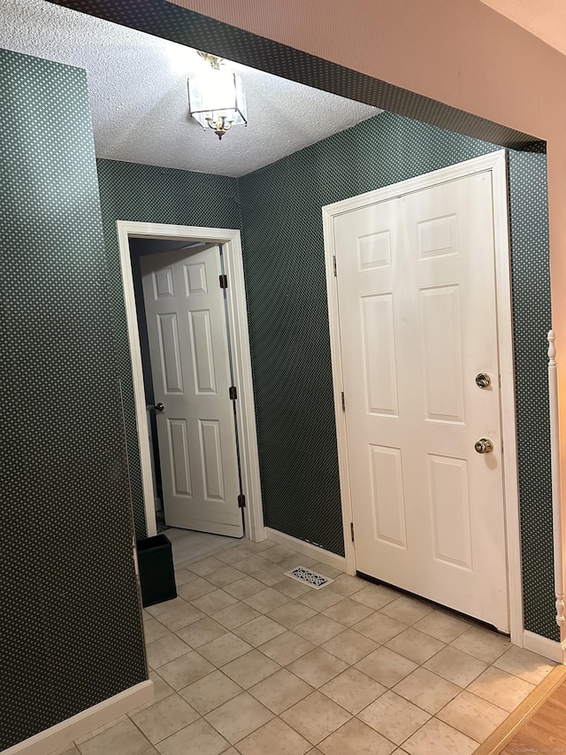 entrance foyer featuring a textured ceiling and light tile patterned flooring