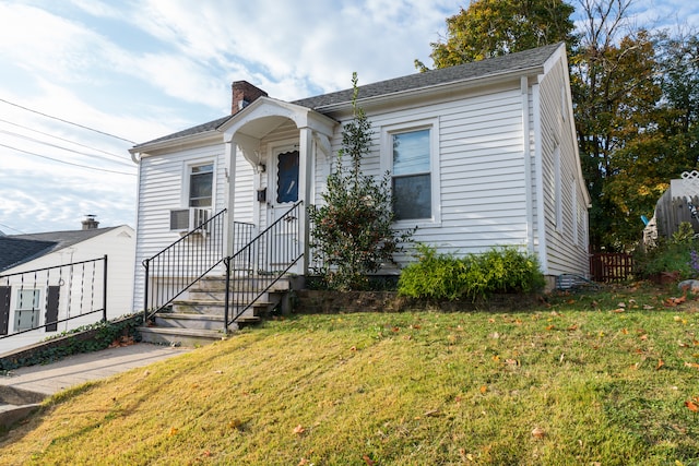 bungalow-style home featuring cooling unit and a front lawn