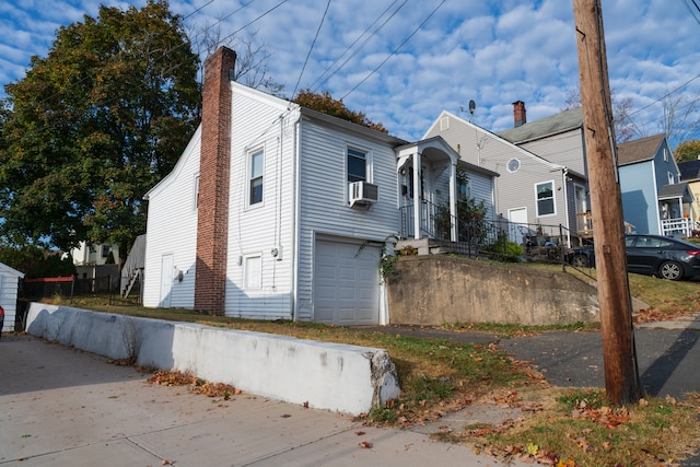 view of front of property with a garage and cooling unit