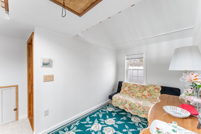 living area featuring vaulted ceiling and light tile patterned flooring