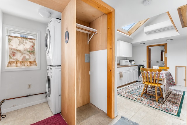 laundry area with stacked washer and dryer, a wall mounted air conditioner, and a skylight