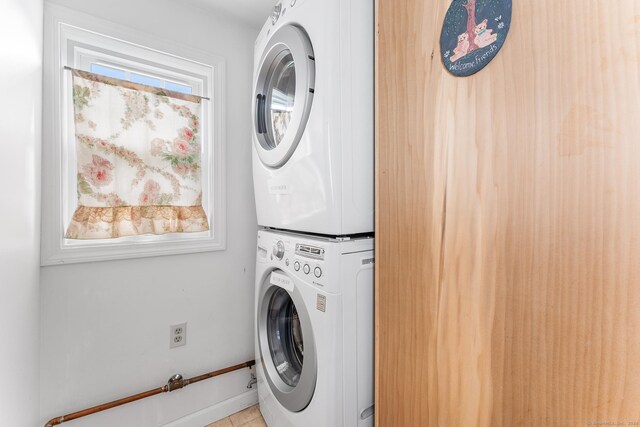 53 Breen Ave, Old Lyme, CT 06371 - laundry area with stacked washing machine and dryer, light tile patterned flooring, and baseboards