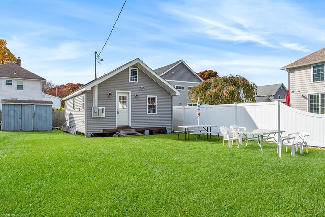 back of house featuring a yard and a storage unit