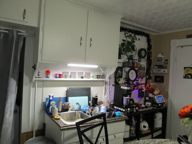 kitchen featuring sink, crown molding, white cabinets, and stainless steel fridge