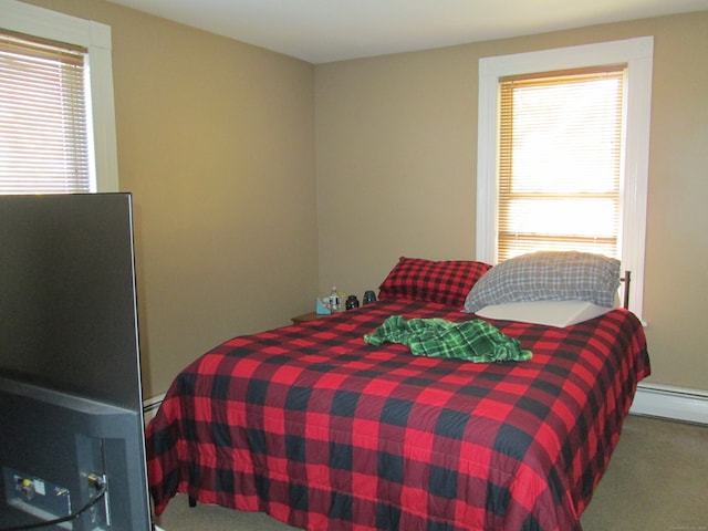 bedroom featuring multiple windows, a baseboard radiator, and carpet