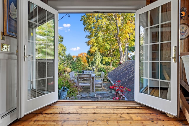 doorway with baseboard heating and wood finished floors